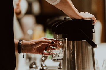 Image showing The waiter preparing coffee for hotel guests. Close up photo of service in modern hotels