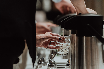 Image showing The waiter preparing coffee for hotel guests. Close up photo of service in modern hotels