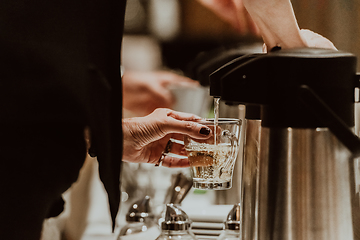 Image showing The waiter preparing coffee for hotel guests. Close up photo of service in modern hotels