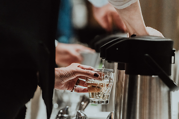 Image showing The waiter preparing coffee for hotel guests. Close up photo of service in modern hotels