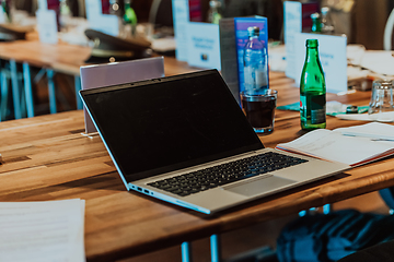 Image showing A laptop on the table of a large seminar hall