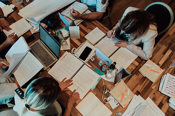 Image showing Top view of colleagues sorting out paperwork together. Businessman working with documentation