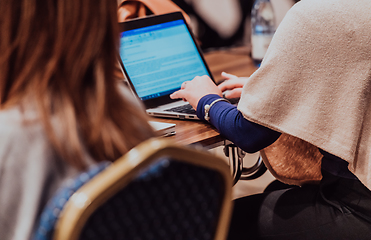 Image showing Close up photo of a woman's hand using on a laptop at a seminar