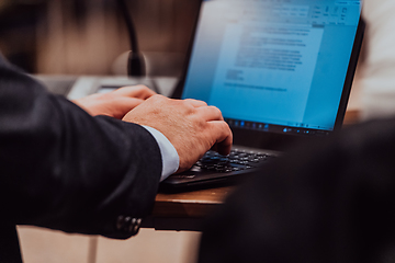 Image showing Close up photo of a businessman typing on a laptop