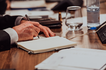 Image showing Closeup shot of business people hands using pen while taking notes on education training during business seminar at modern conference room