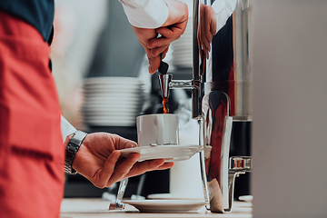 Image showing The waiter preparing coffee for hotel guests. Close up photo of service in modern hotels