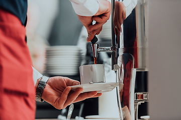 Image showing The waiter preparing coffee for hotel guests. Close up photo of service in modern hotels