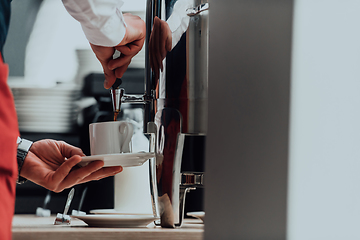 Image showing The waiter preparing coffee for hotel guests. Close up photo of service in modern hotels