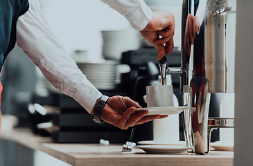 Image showing The waiter preparing coffee for hotel guests. Close up photo of service in modern hotels