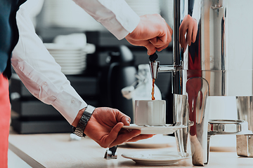 Image showing The waiter preparing coffee for hotel guests. Close up photo of service in modern hotels