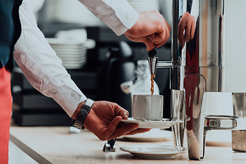 Image showing The waiter preparing coffee for hotel guests. Close up photo of service in modern hotels