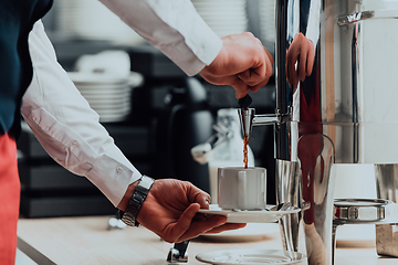 Image showing The waiter preparing coffee for hotel guests. Close up photo of service in modern hotels