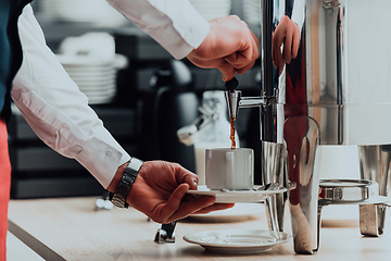 Image showing The waiter preparing coffee for hotel guests. Close up photo of service in modern hotels