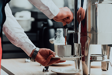 Image showing The waiter preparing coffee for hotel guests. Close up photo of service in modern hotels