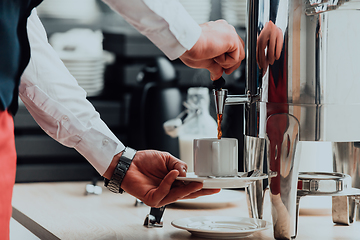 Image showing The waiter preparing coffee for hotel guests. Close up photo of service in modern hotels