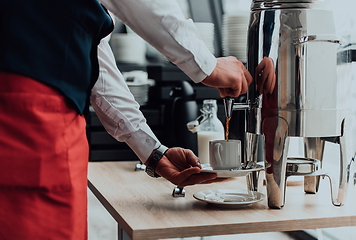 Image showing The waiter preparing coffee for hotel guests. Close up photo of service in modern hotels