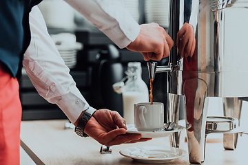 Image showing The waiter preparing coffee for hotel guests. Close up photo of service in modern hotels