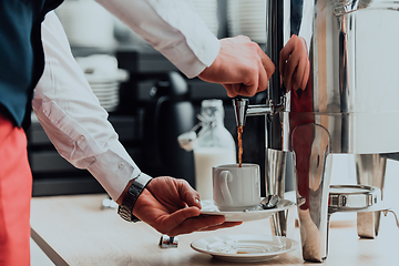 Image showing The waiter preparing coffee for hotel guests. Close up photo of service in modern hotels