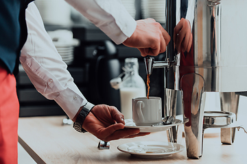 Image showing The waiter preparing coffee for hotel guests. Close up photo of service in modern hotels