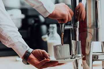 Image showing The waiter preparing coffee for hotel guests. Close up photo of service in modern hotels