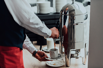 Image showing The waiter preparing coffee for hotel guests. Close up photo of service in modern hotels