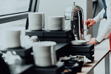 Image showing The waiter preparing coffee for hotel guests. Close up photo of service in modern hotels