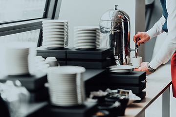 Image showing The waiter preparing coffee for hotel guests. Close up photo of service in modern hotels