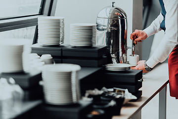 Image showing The waiter preparing coffee for hotel guests. Close up photo of service in modern hotels