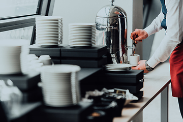 Image showing The waiter preparing coffee for hotel guests. Close up photo of service in modern hotels