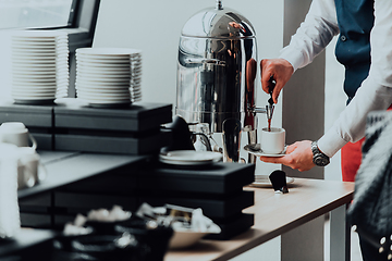 Image showing The waiter preparing coffee for hotel guests. Close up photo of service in modern hotels