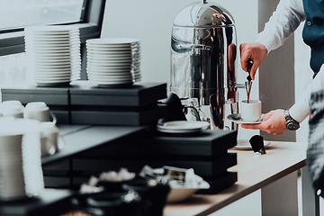 Image showing The waiter preparing coffee for hotel guests. Close up photo of service in modern hotels