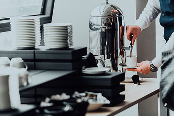 Image showing The waiter preparing coffee for hotel guests. Close up photo of service in modern hotels