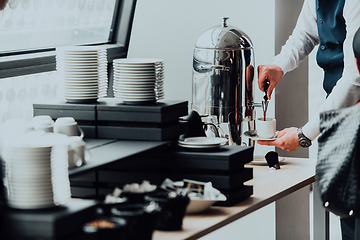 Image showing The waiter preparing coffee for hotel guests. Close up photo of service in modern hotels