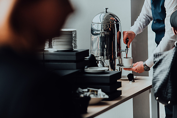 Image showing The waiter preparing coffee for hotel guests. Close up photo of service in modern hotels