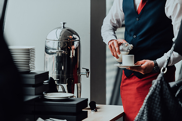 Image showing The waiter preparing coffee for hotel guests. Close up photo of service in modern hotels