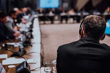 Image showing Speaker at Business Conference with Public Presentations. Audience at the conference hall. Entrepreneurship club. Rear view. Panoramic composition. Background blur.