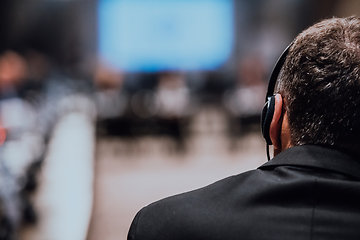 Image showing Speaker at Business Conference with Public Presentations. Audience at the conference hall. Entrepreneurship club. Rear view. Panoramic composition. Background blur.