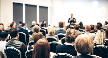 Image showing Speaker giving a talk in conference hall at business event. Rear view of unrecognizable people in audience at the conference hall. Business and entrepreneurship concept.