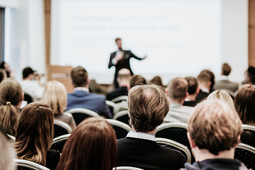 Image showing Speaker giving a talk in conference hall at business event. Rear view of unrecognizable people in audience at the conference hall. Business and entrepreneurship concept.