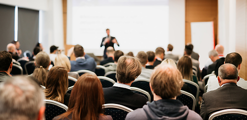 Image showing Speaker giving a talk in conference hall at business event. Rear view of unrecognizable people in audience at the conference hall. Business and entrepreneurship concept.