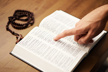 Image showing Hands, person and reading bible with rosary cross for praying, spiritual faith and holy worship of God. Closeup of christian studying religion, gospel prayer books and learning praise to Jesus Christ