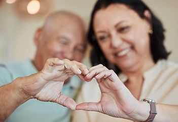 Image showing Hands, heart and love with a senior couple in their home for health, wellness or trust during retirement. Emoji, shape or hand gesture with an elderly man and woman closeup in their house together