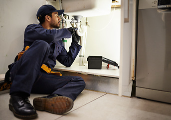 Image showing Plumbing, handyman and maintenance with man in kitchen for repair, industrial and inspection. Pipes, tools and safety with male plumber fixing sink for home improvement, drainage and water system