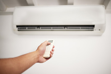 Image showing Air conditioner, hand and remote for electrical machine check with person in a home with ac repair. Maintenance, and system control for installation, inspection of aircon fix in house with contractor