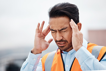 Image showing Headache, stress and male construction worker on a rooftop of a building for inspection or maintenance. Migraine, engineering and young man foreman with burnout while working in an urban town.