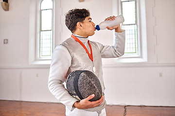 Image showing Sports, fencing and man drinking water for training, fitness or workout with helmet in club. Bottle, fencer or athlete with beverage after exercise with liquid for nutrition, body health or wellness