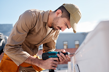 Image showing Technician man, drill and outdoor with air conditioner maintenance, roof or building in metro cbd for construction. AC repair, hvac tech and tools for engineer, service and aircon industry on rooftop