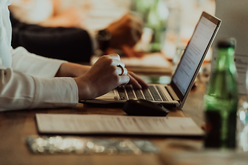 Image showing Close up photo of a woman's hand typing on a laptop at a seminar