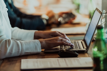 Image showing Close up photo of a woman's hand typing on a laptop at a seminar