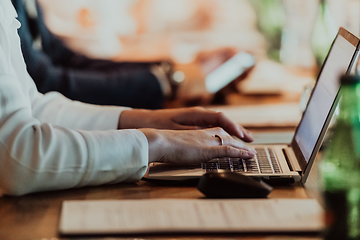 Image showing Close up photo of a woman's hand typing on a laptop at a seminar